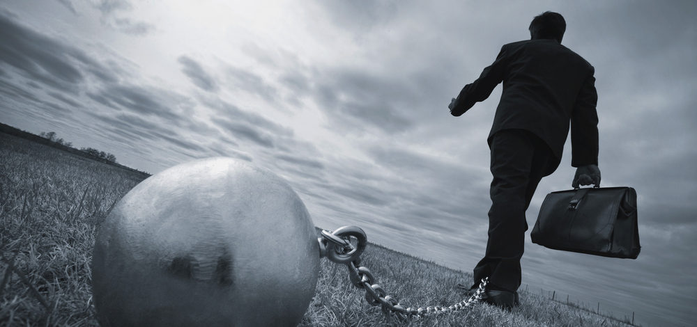 businessman tied to a ball-and-chain | compliance management process ROI of TCT Portal