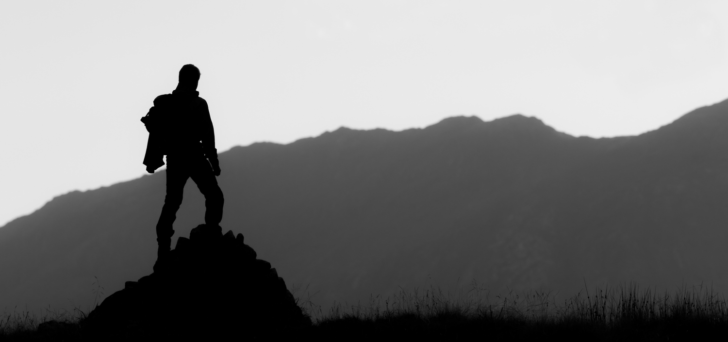 Black and white silhouette of hiker on the top of the hill | TCT compliance consulting services