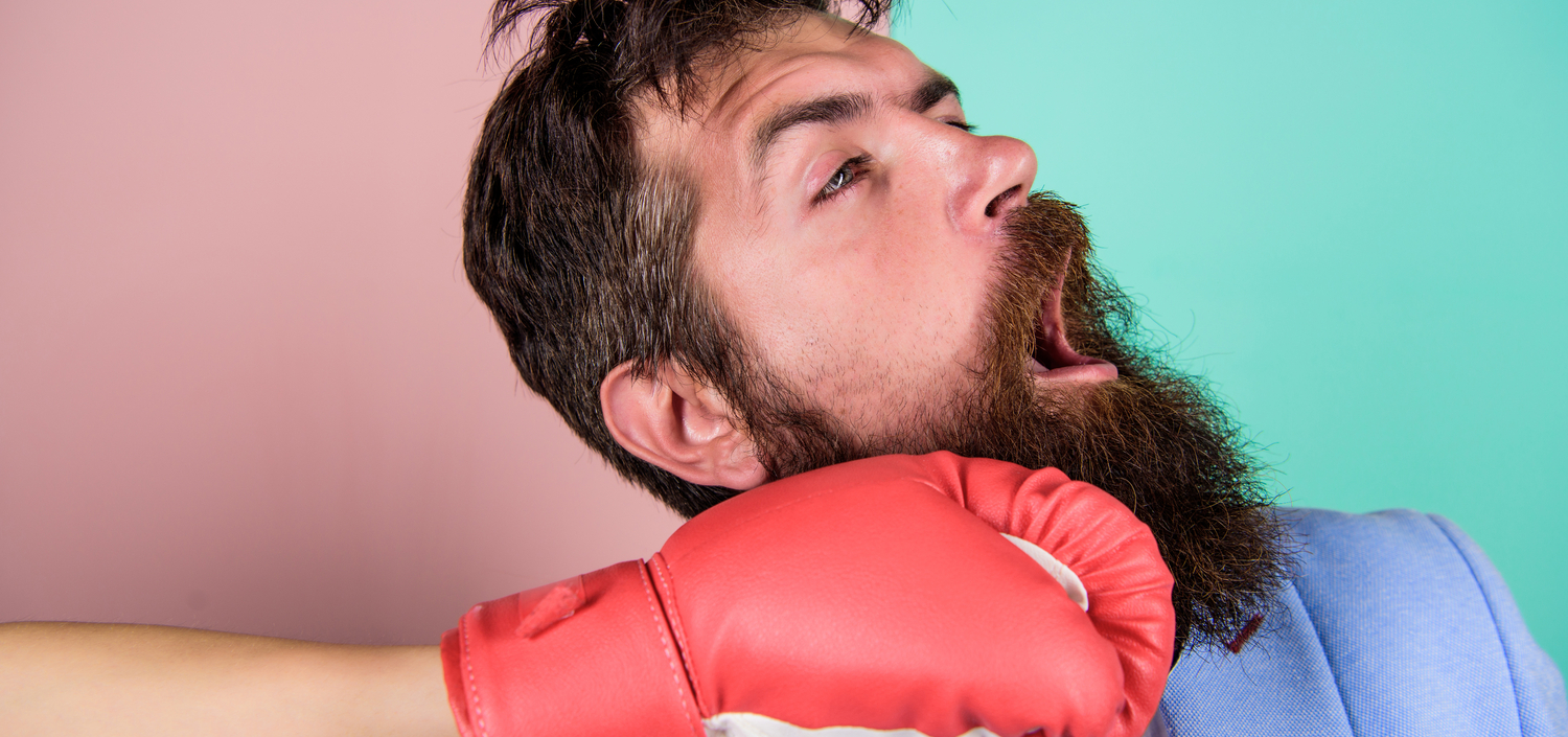 Businessman getting punched in the face with a boxing glove | cyber liability insurance bill increases
