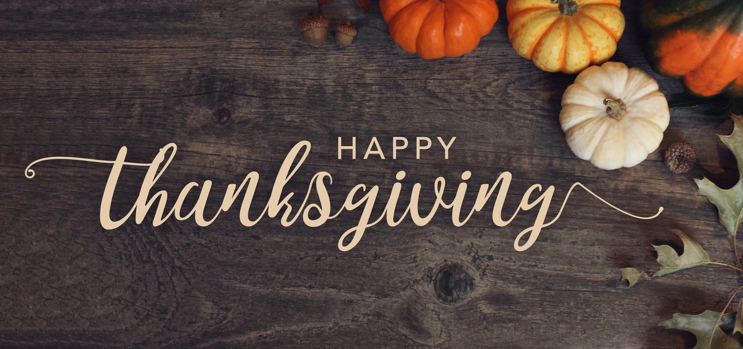 Happy Thanksgiving text with pumpkins and leaves over dark wood background
