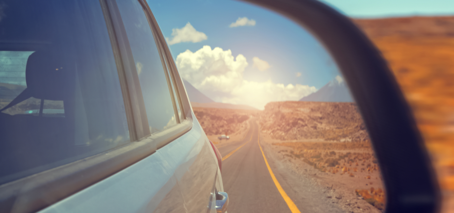 Reflection of a highway in a car sideview mirror | compliance unfiltered year in review