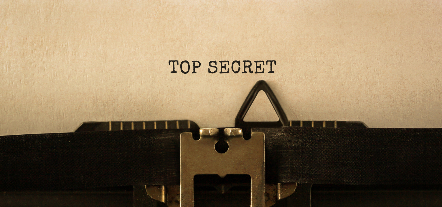 closeup of a sheet of paper in a typewriter with "Top Secret" typed on it | protecting your stored sensitive data