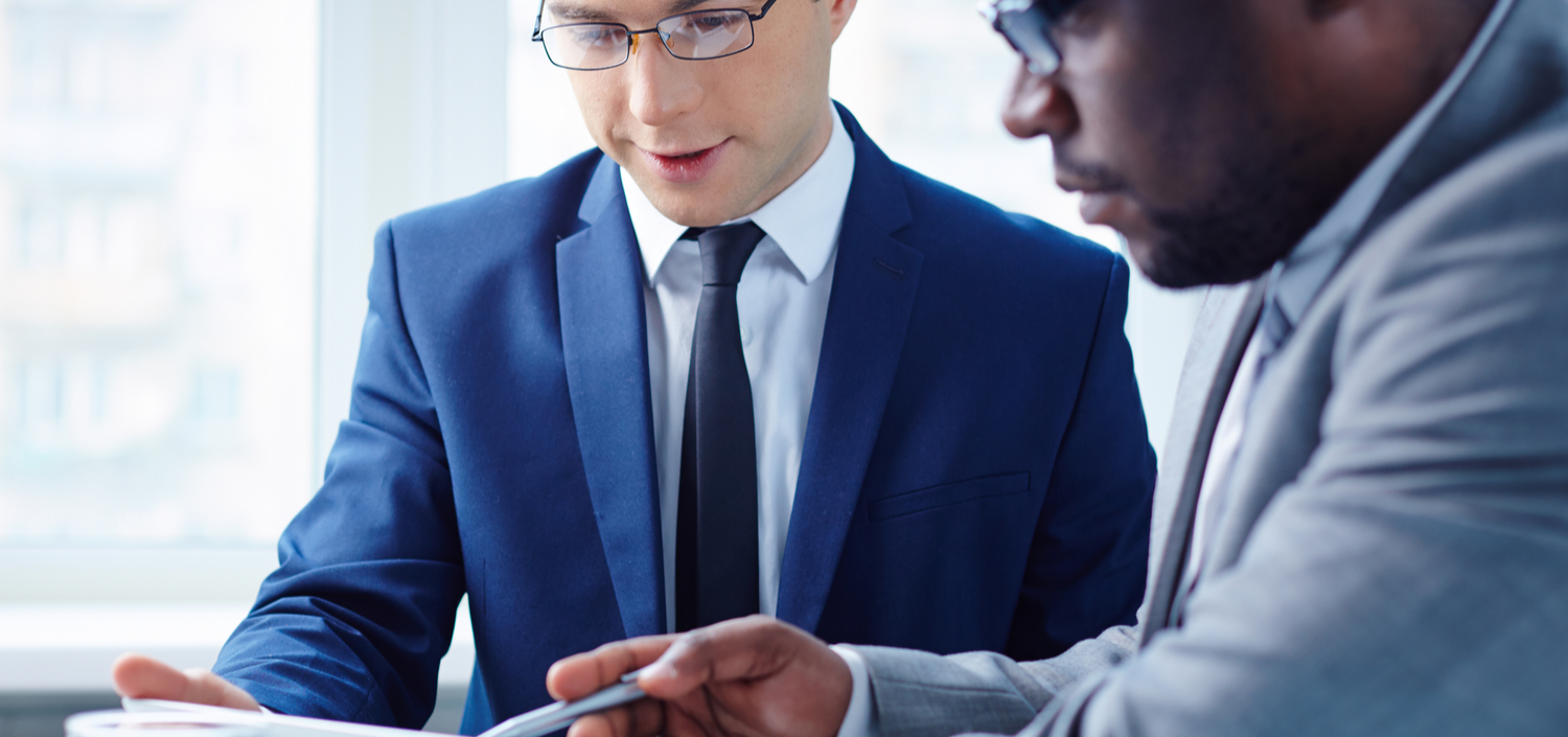 two young businessmen discussing a business case for a compliance management system