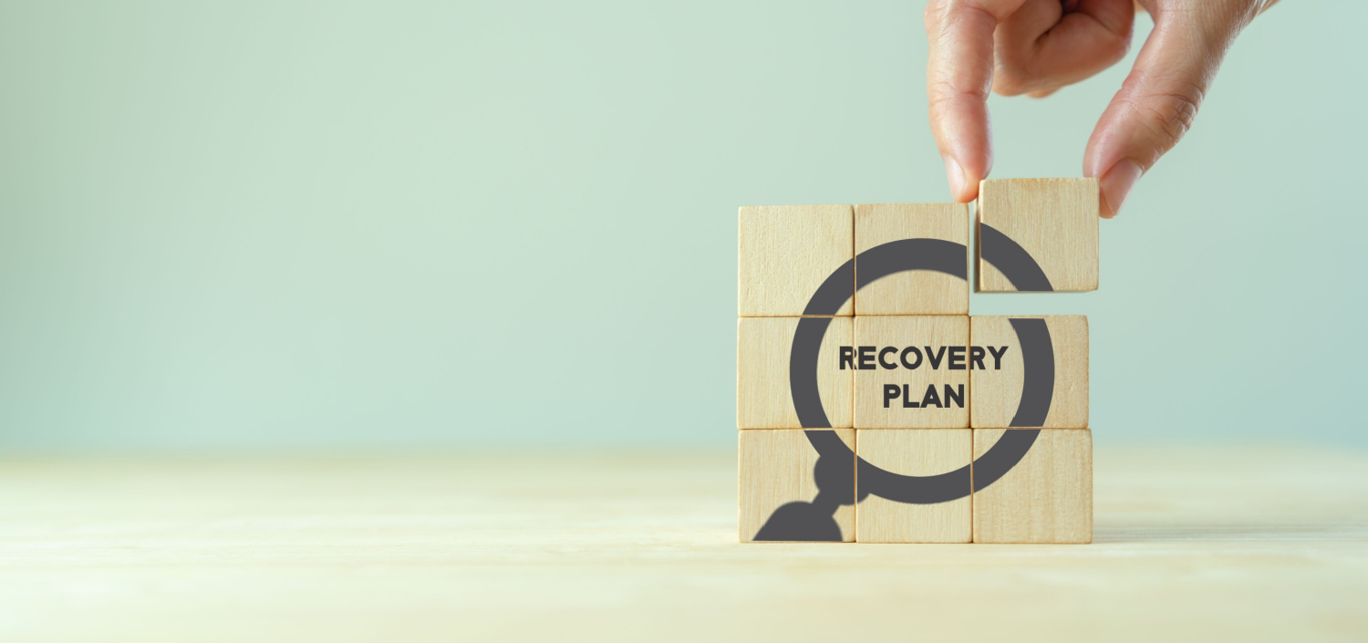 stack of wooden blocks in a 3x3 grid that say “recovery plan” | What Is Business Continuity and Disaster Recovery