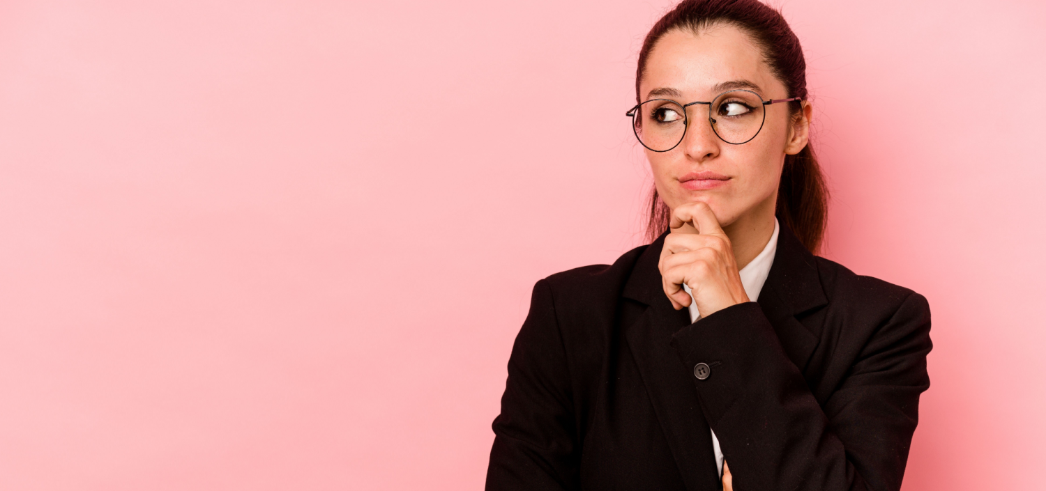 Young business woman isolated on pink background looking sideways | CMMC SPRS score
