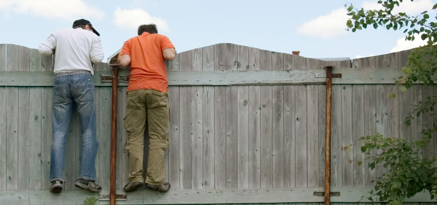 2 men looking over a fence | CMMC