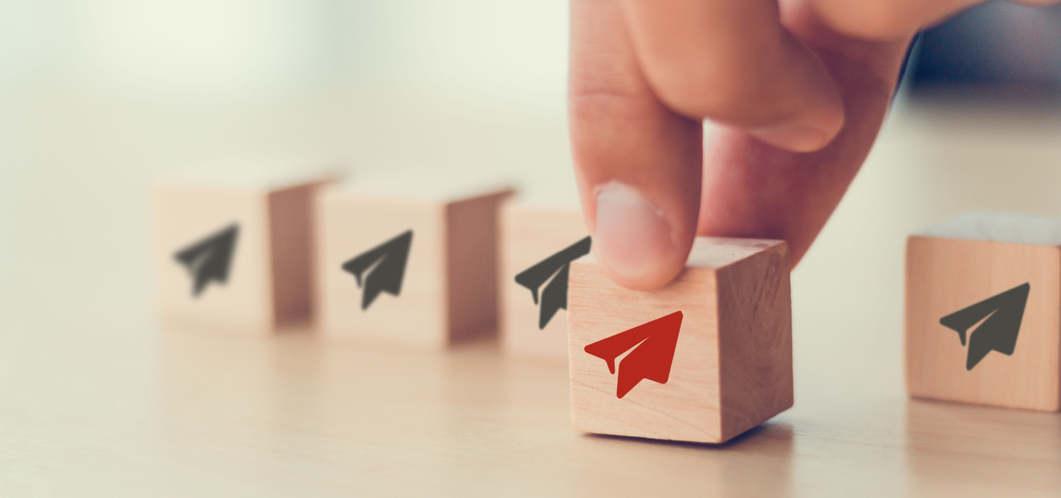 Businessman chooses red paper plane symbol on wooden cube standing with others on white | custom certifications