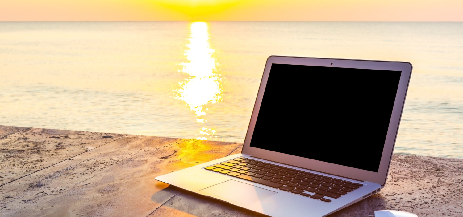 laptop on a beach at sunset | summer cyberattacks