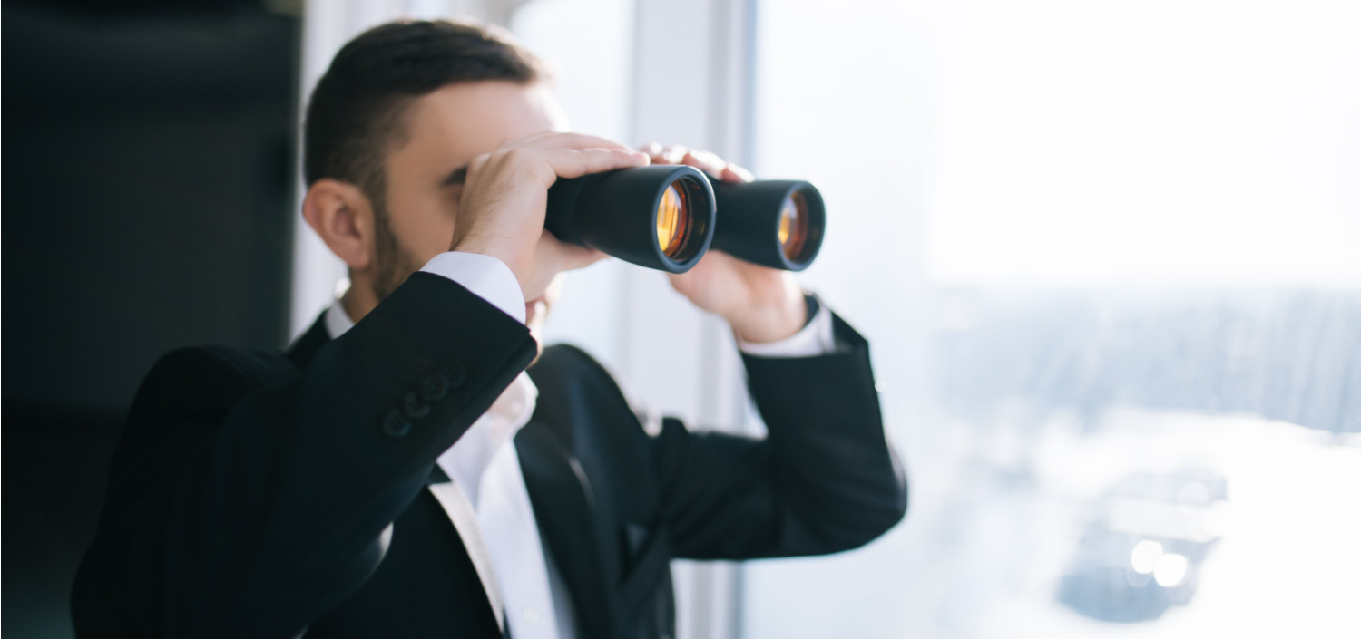 businessman with binoculars | Cybersecurity Trends to Watch in 2024