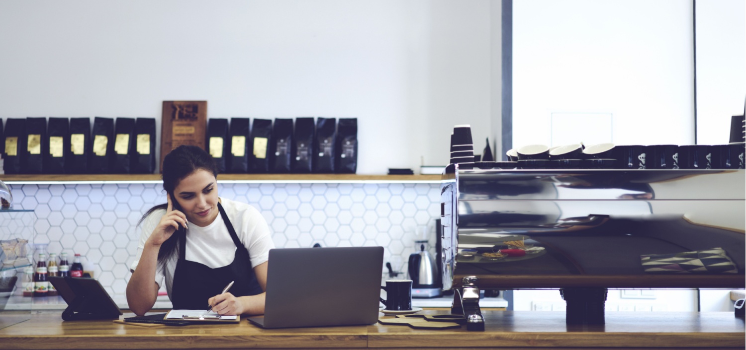 female franchise owner working behind the counter | PCI-DSS compliance for franchise corporations
