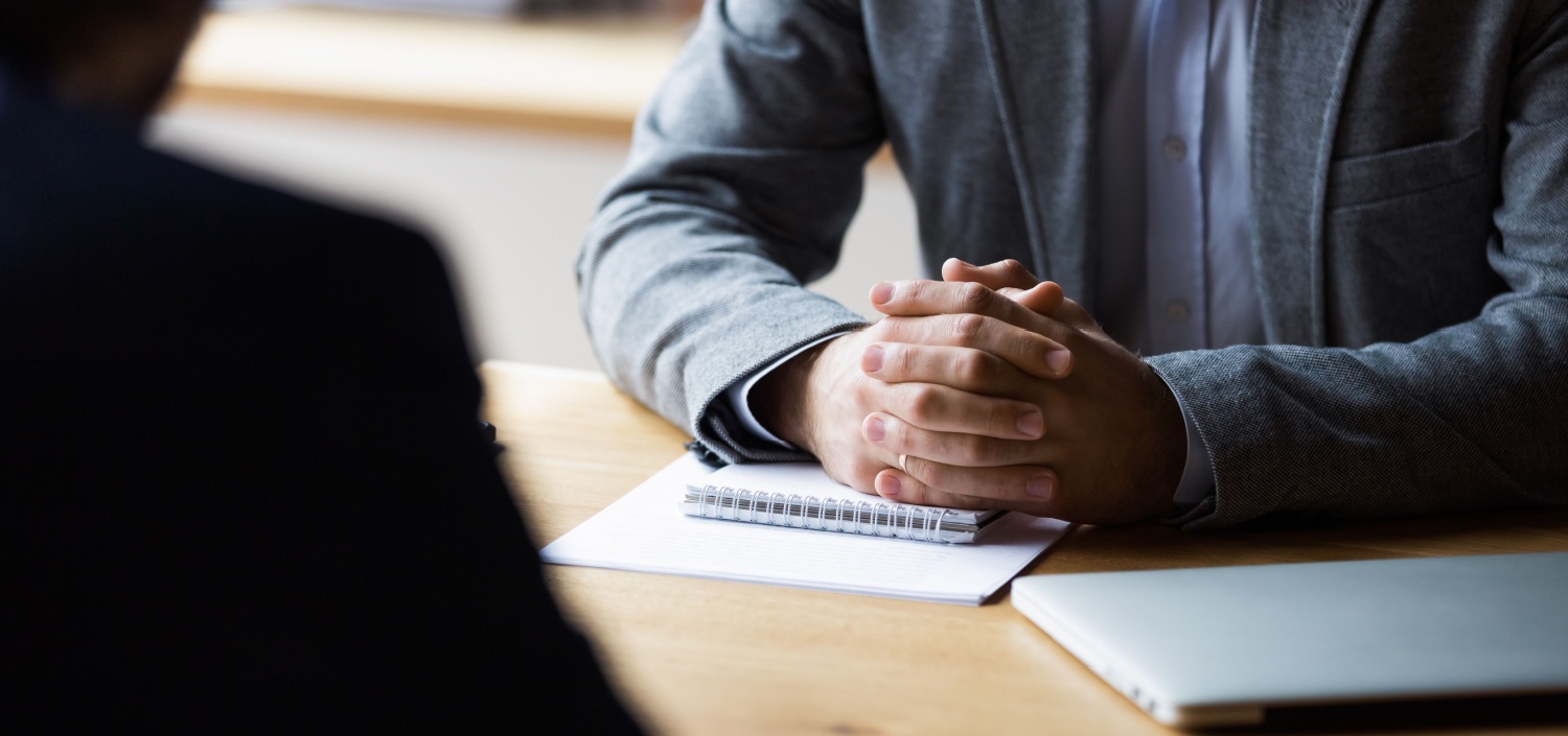 closeup of Assessor’s hands clasped on a table during a PCI assessment